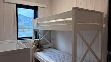 Un lit superposé avec un matelas et un ours en peluche sur le lit du bas.