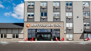 A modern building with a sign reading 'AMSTERDAM INN' and multiple windows.