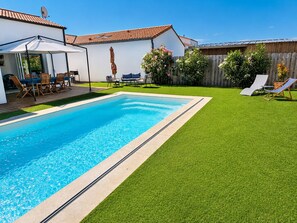 A rectangular swimming pool with a tiled edge, surrounded by artificial green grass. - Le Hâvre des Dunes - Piscine (Brem-sur-Mer)