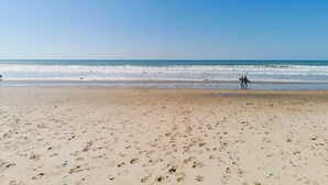 A beach with footprints leading to the water, a clear sky, and a calm sea. - Le Hâvre des Dunes - Piscine (Brem-sur-Mer)
