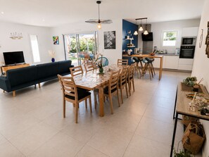 Eine moderne Küche mit Essbereich, einer Couch und einem Fernseher.