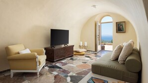 Un salon confortable avec une télévision, des canapés et une vue sur la mer.