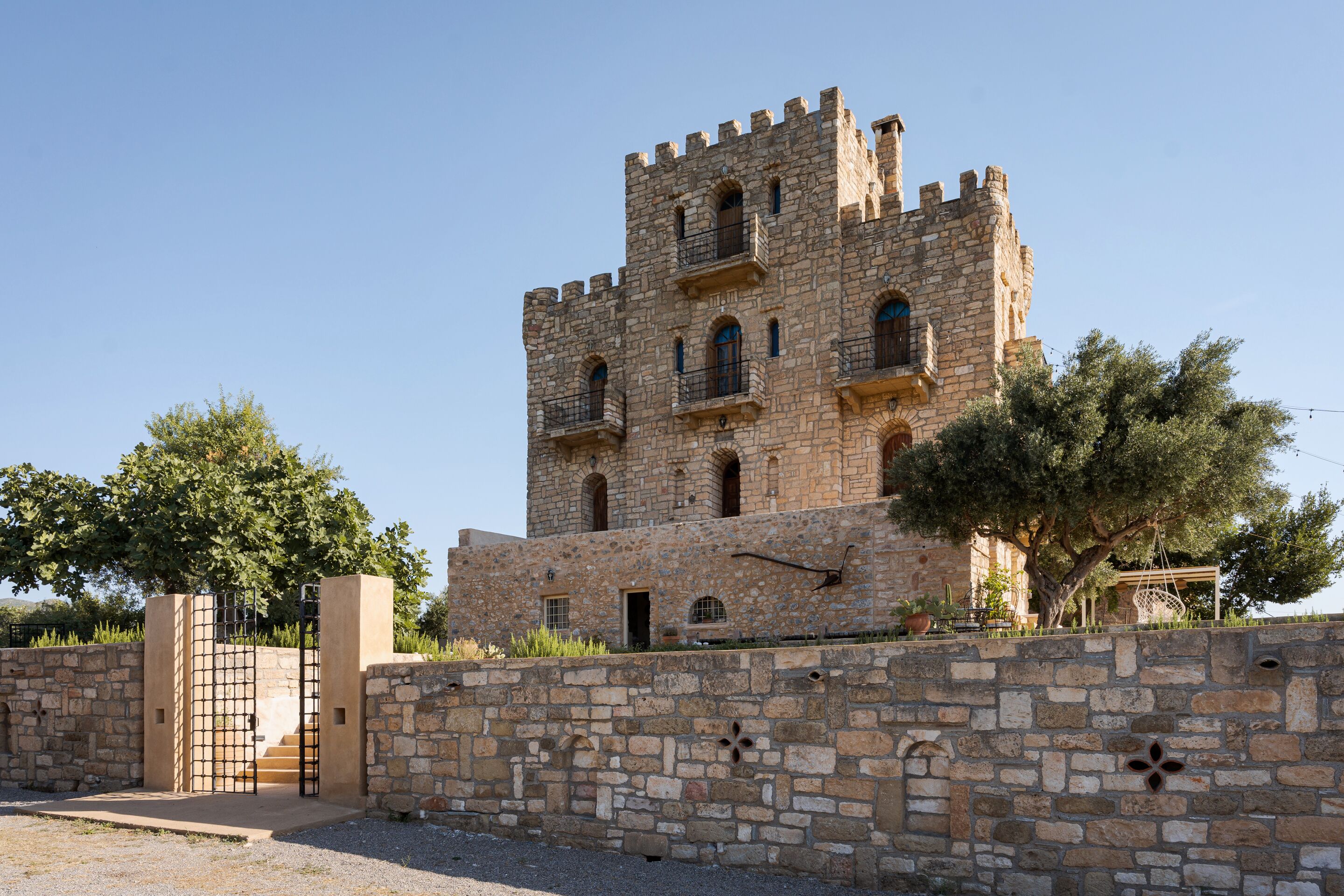 A historic stone tower with multiple windows and a gated entrance.
