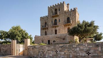 A historic stone tower with multiple windows and a gated entrance.