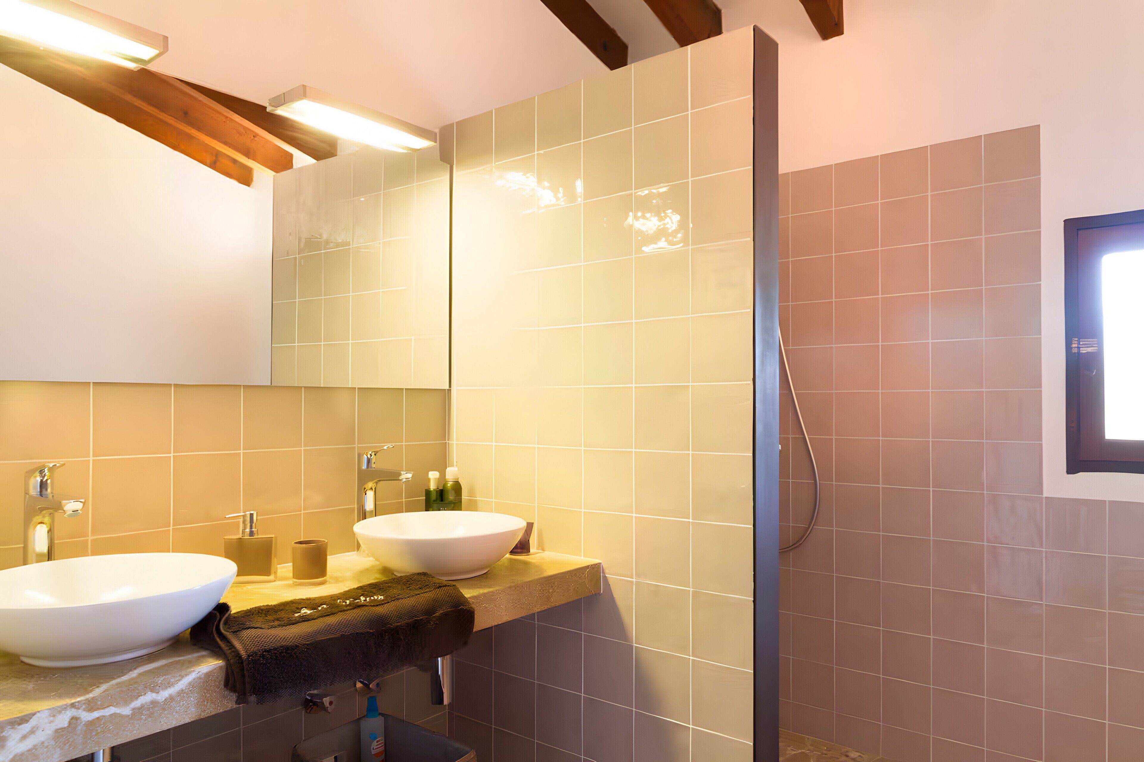 Une salle de bain avec deux lavabos, un miroir et une douche.