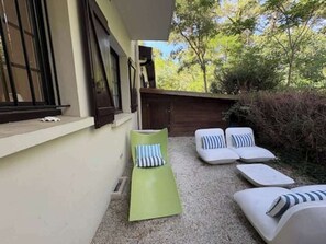 A patio with outdoor seating, including a green lounge chair and multiple white cushioned chairs with striped pillows. - 61-square-meter apartment with an 85-square-meter terrace and direct access to the pool. Hossegor Lake (Soorts-Hossegor)