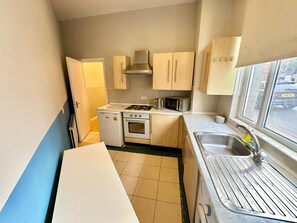 A compact kitchen with a stove, oven, microwave, and sink. - Cozy Studio beautiful London perfect for your stay (London)