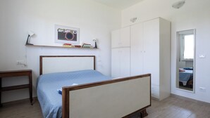 A bedroom with a bed, a wardrobe, a desk, and a mirror. - Lilli's House (Ponte Buggianese)