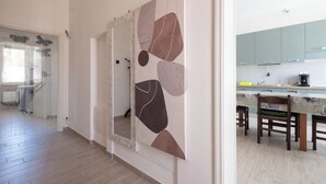 A modern kitchen with a dining area, a hallway with a mirror, and a staircase. - Lilli's House (Ponte Buggianese)