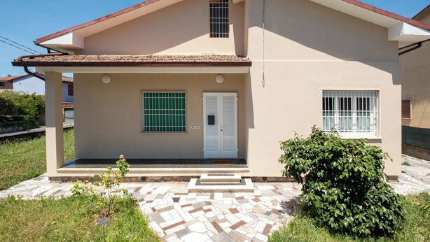 A two-story house with a tiled roof, a front door with shutters, and a small window with bars. - Lilli's House (Ponte Buggianese)