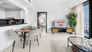 Un soggiorno moderno con zona pranzo, cucina e una grande finestra.
