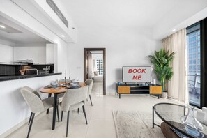 Ein modernes Wohnzimmer mit Essbereich, einer Küche und einem großen Fenster.