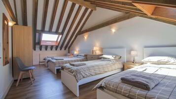 A bedroom with two beds, a desk, and a chair.