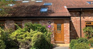 A brick house with a wooden door, windows, and a garden. - Knavesmire Cottage - Hot Tub, sleeps 10 (York)