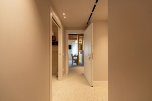 Un passadís amb una porta que dona a una habitació amb zona de menjador.
