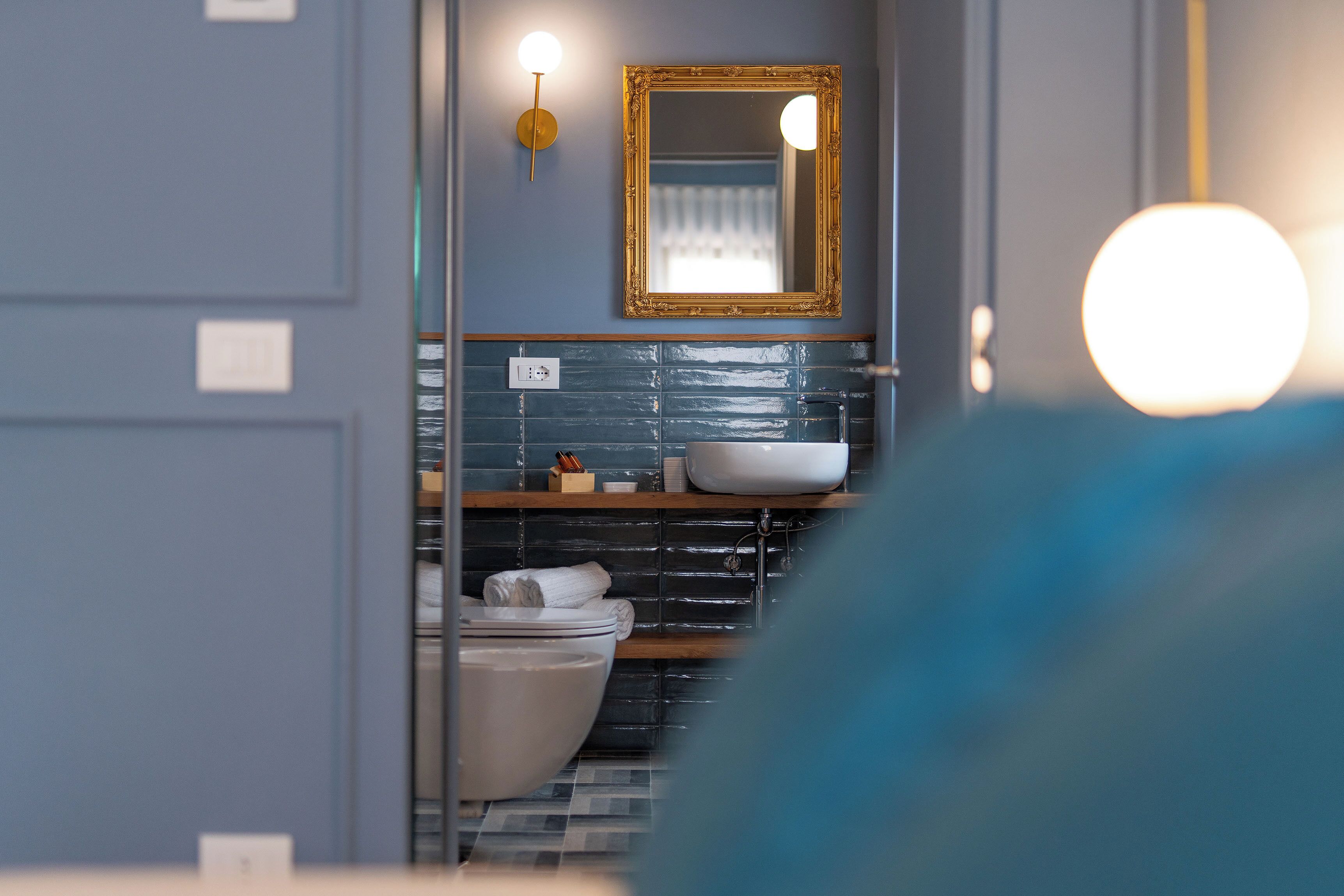 Une salle de bain avec une baignoire blanche, un lavabo et un miroir doté d’un cadre doré.