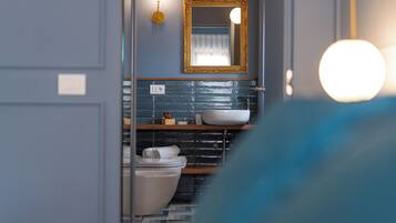 Une salle de bain avec une baignoire blanche, un lavabo et un miroir doté d’un cadre doré.