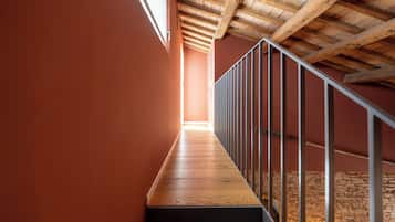 A wooden staircase with a metal railing leading to an upper level.