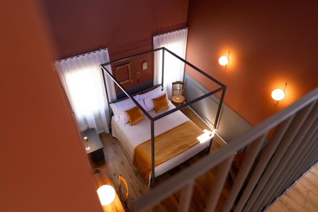 Ein Zimmer mit einem Bett, einem Sessel und einem Nachttisch.
