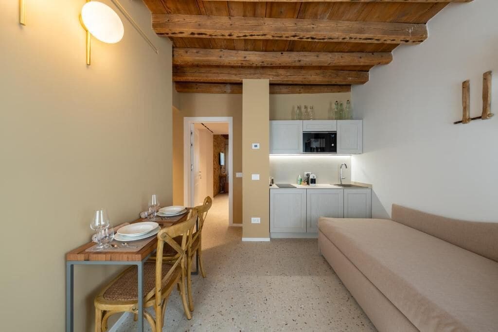 A cozy interior with a dining area, kitchenette, and a sofa.