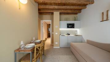 A cozy interior with a dining area, kitchenette, and a sofa.