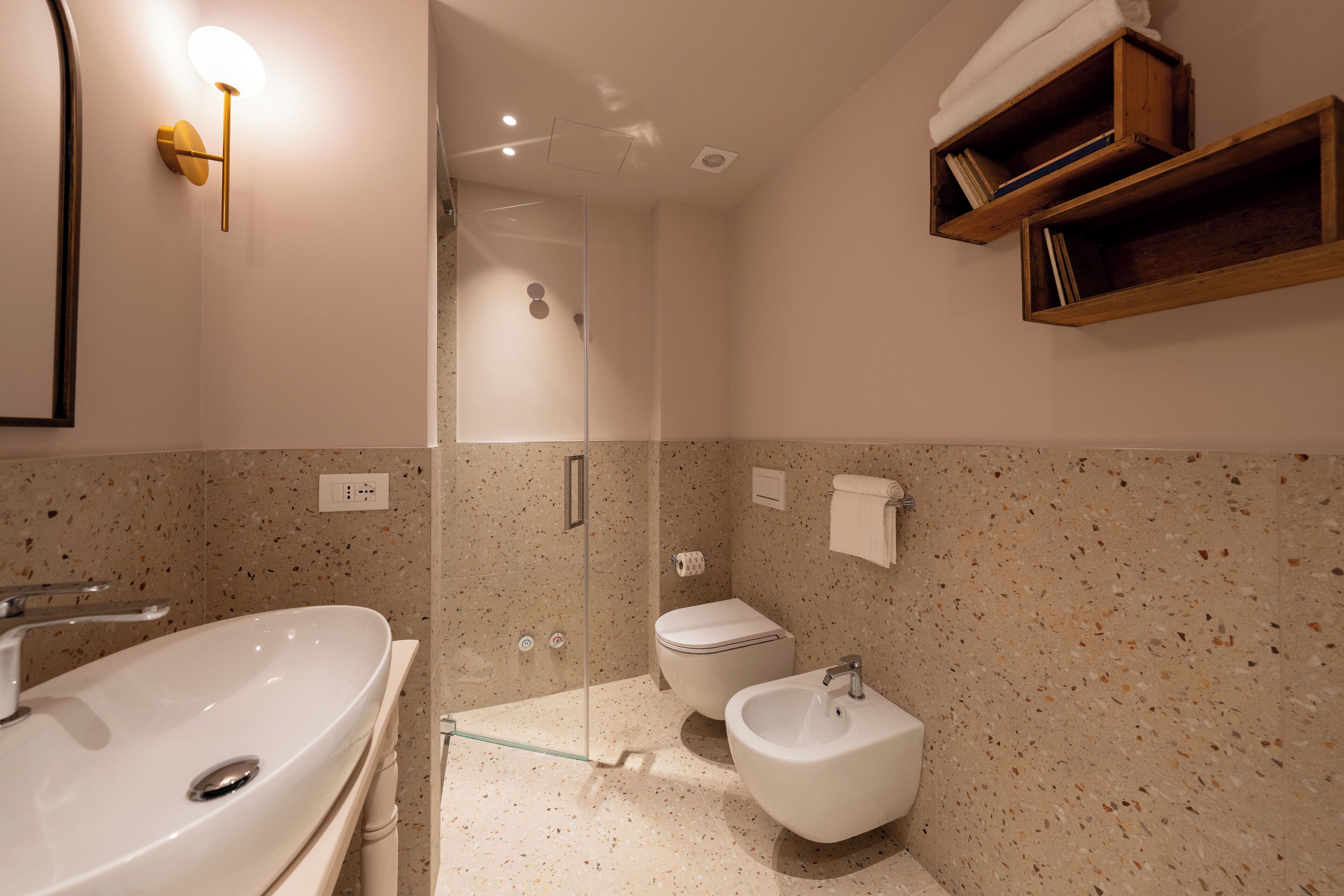 Un baño con lavamanos grande, inodoro, bidé y zona de ducha.