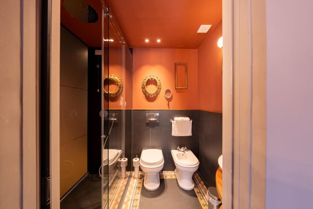Un baño con inodoro, bidé y toallero.