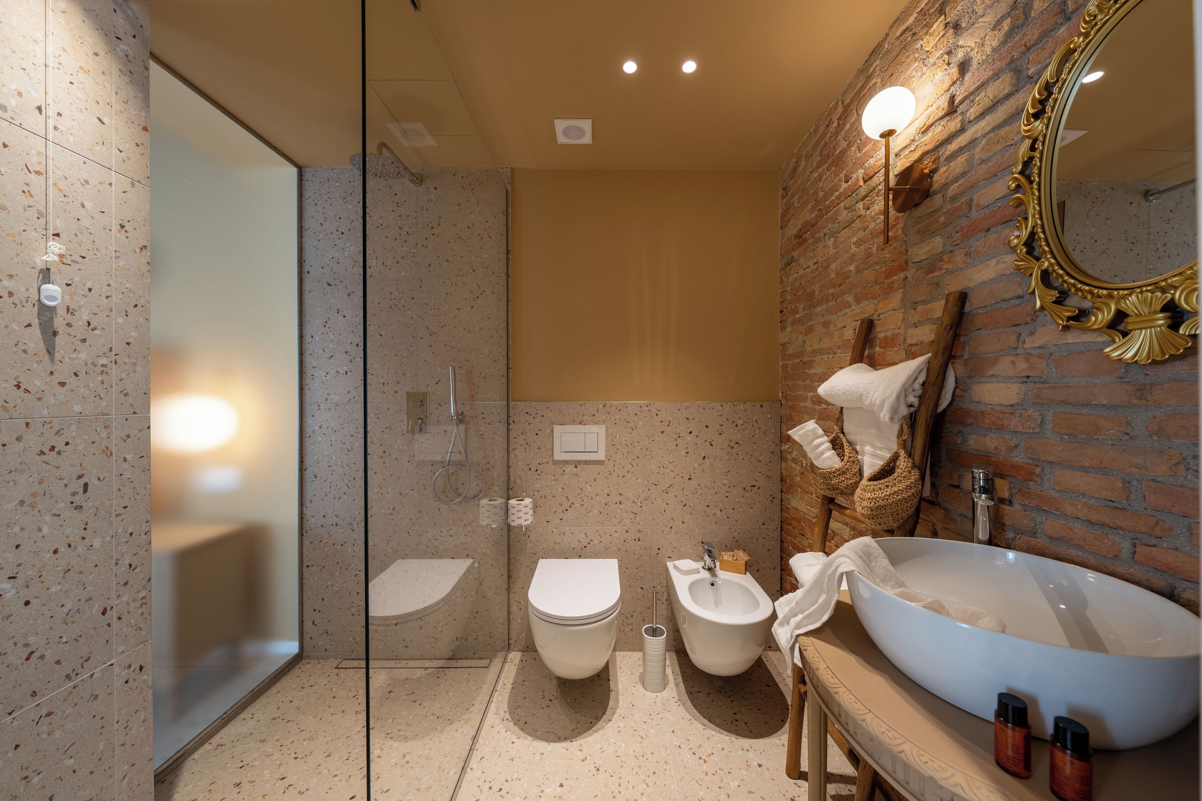 A modern bathroom with a large mirror, a freestanding sink, and a shower area.