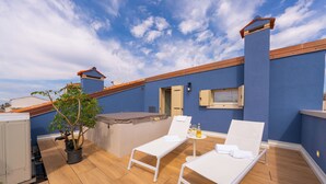 A rooftop terrace with two white lounge chairs, a small table with a bottle and glasses, a potted plant, and a satellite dish. - Spaccavento Boutique Rooms (Chioggia)