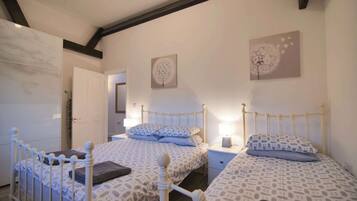 A bedroom with two beds, a wardrobe, and a door.