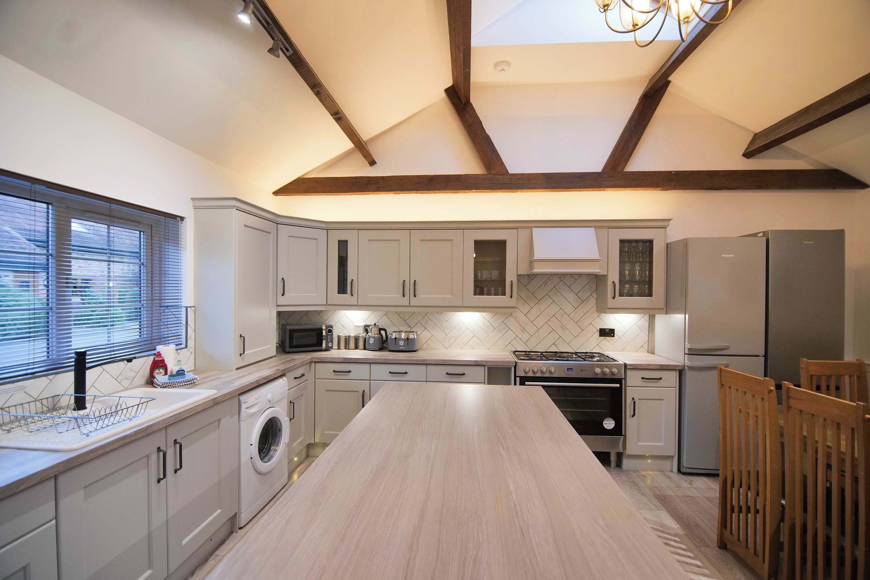 A modern kitchen with a central island, built-in appliances, and a skylight.
