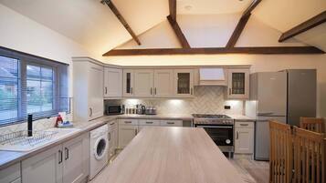 A modern kitchen with a central island, built-in appliances, and a skylight.