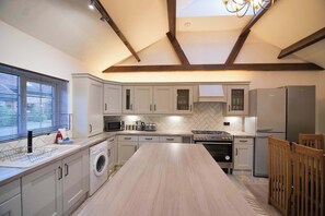 A modern kitchen with a central island, built-in appliances, and a skylight.