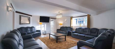 A modern living room with two sofas, a coffee table, and a TV.