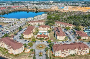 A residential area with apartment buildings, a central pool, and a circular driveway. - Pink Apple l Modern Comfort (Davenport)