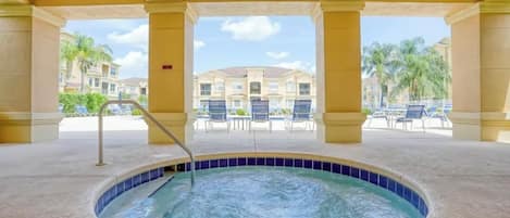 A hot tub area with a view of a building and palm trees.