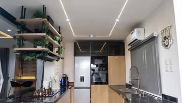 A modern kitchen with a central island, built-in appliances, and pendant lighting.