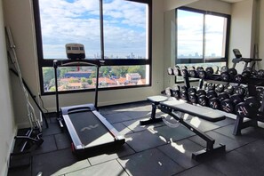 A gym with a treadmill, bench, and weight rack. - Recoleta Studio with Balcony • Couples, remote workers, business travelers (Asunción)
