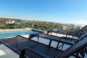 A rooftop pool area with lounge chairs and a view of a cityscape. - Recoleta Studio with Balcony • Couples, remote workers, business travelers (Asunción)