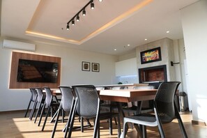 Une cuisine moderne avec un coin repas, comprenant une table en bois, des chaises noires et un grand tableau accroché au-dessus du comptoir.