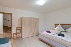 A bedroom with a bed, a wardrobe, a chair, and a staircase. - Nasdala Holiday Apartment: Relax with Stunning Panoramic Views (Bühlertal)