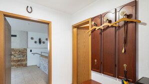 A hallway with a wooden door, a coat rack, and a small table.