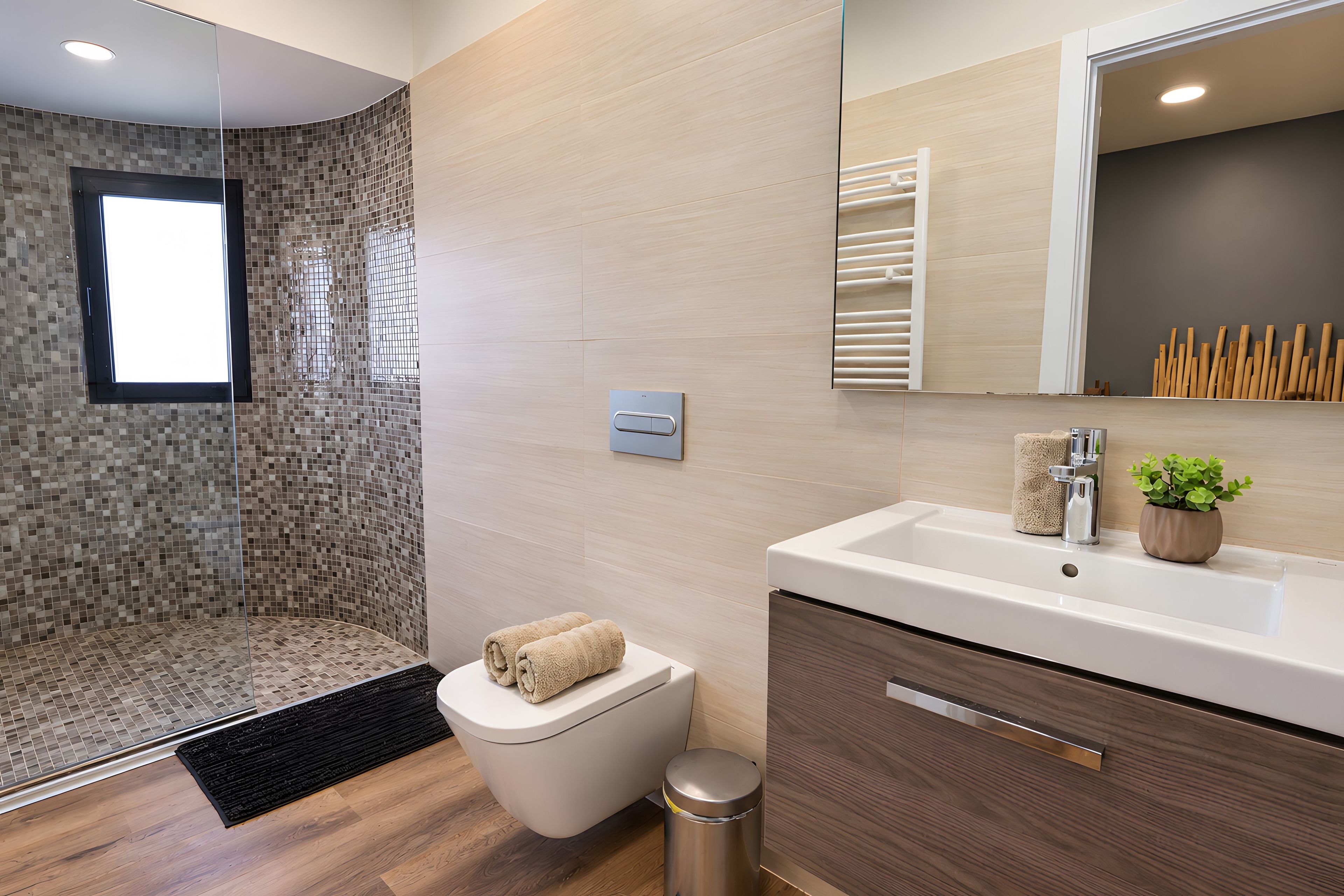 Un baño moderno con ducha, inodoro, lavamanos y espejo.