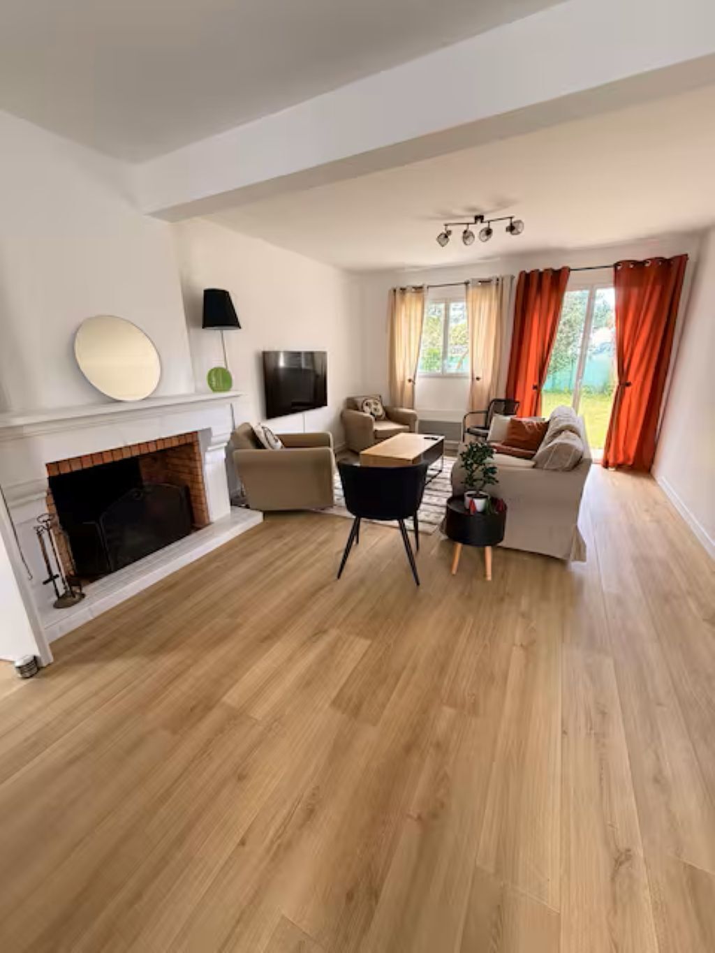 Ein modernes Wohnzimmer mit Kamin, Flachbildfernseher und einer Sofagarnitur.