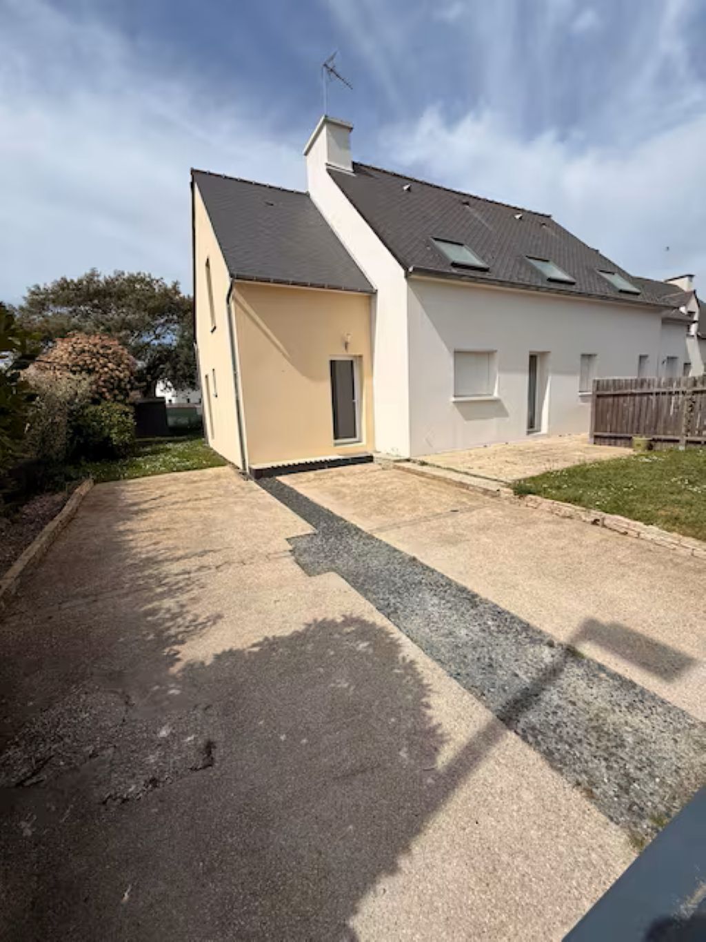 A two-story house with a driveway leading to a garage.