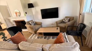 A modern living room with a sofa, a coffee table, and a flat-screen TV.