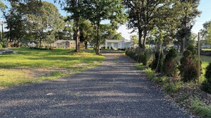 Camí de grava que condueix a una filera de cases mòbils, amb una zona verda a cada costat.