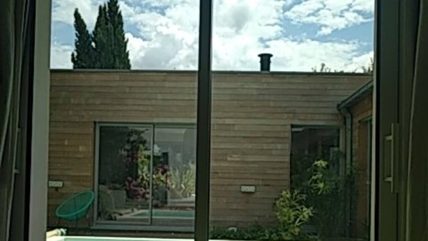 A modern building with a pool, a sliding glass door, and a view of the sky. - A Little Paradise with a Pool in the Heart of Nantes (Nantes)
