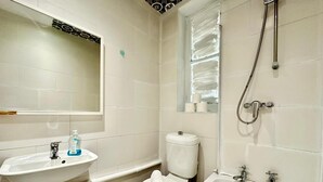 Un baño con lavamanos, inodoro, bañera y ducha.