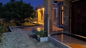 A modern house with a gravel driveway, a covered porch, and a garage. - MIHAMBOS RESIDENCE (Msambweni)